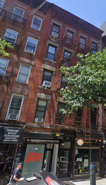 Nyc apartment for rent - a man walking down a street in front of a building