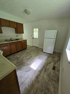 Morehead house for rent - an empty kitchen with a refrigerator and a sink