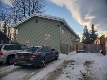 Anchorage apartment for rent - a house with a car parked in front of it in the snow