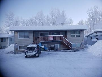 Anchorage apartment for rent - A house with a car parked in front of it.