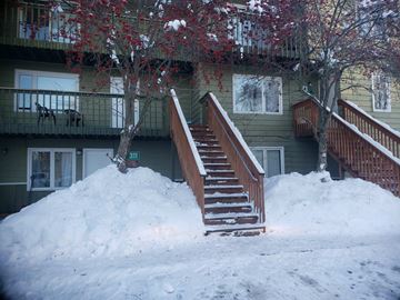 Anchorage apartment for rent - A large pile of snow in front of a building with a staircase.
