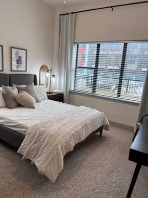 Plano house for rent - a bedroom with a bed and a large window