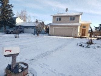 Anchorage house for rent - A mailbox sits on a snowy ground in front of a house.