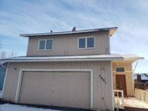 Anchorage house for rent - A two-story house with a garage door and a deck.