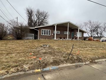 Omaha apartment for rent - a house on a grassy yard with a dirt road