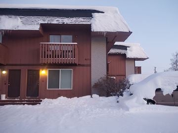 Anchorage apartment for rent - A house with a brown exterior is covered in snow.