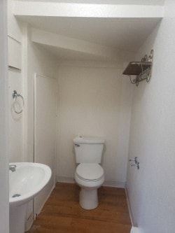 Anchorage apartment for rent - A white toilet sits in a small bathroom with a white tub and a towel rack.