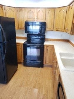 Anchorage apartment for rent - A black refrigerator stands next to a black oven in a kitchen.