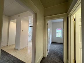 Mckeesport house for rent - a view of a living room and a hallway with a door open