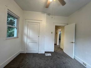 Mckeesport house for rent - a bedroom with a carpeted floor and a ceiling fan