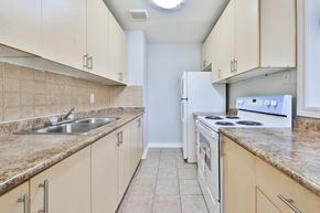 Mississauga apartment for rent - A kitchen with a white refrigerator and white stove.