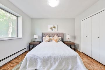 Mississauga apartment for rent - A bedroom with a large bed and a window.