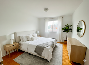 Mississauga apartment for rent - A bedroom with a large bed, a nightstand, and a dresser.