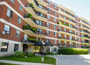 Mississauga apartment for rent - A red brick apartment building with balconies and plants.