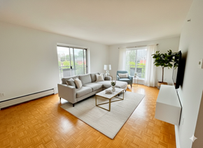 Mississauga apartment for rent - A living room with a grey couch, a white coffee table, and a wooden floor.