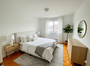 Mississauga apartment for rent - A bedroom with a large bed, a nightstand, and a dresser.