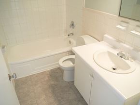 Mississauga apartment for rent - A white bathroom with a toilet, sink, and bathtub.