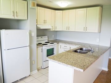 Mississauga apartment for rent - A kitchen with a white refrigerator and a granite counter top.