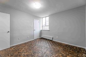 Mississauga apartment for rent - A room with a wooden floor and a window.