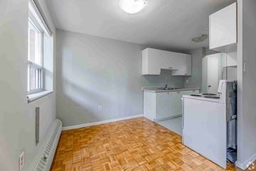 Brampton apartment for rent - A kitchen with white cabinets and a wooden floor.