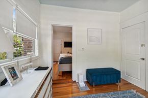 Tampa apartment for rent - A bedroom with a bed, a bench, and a window.