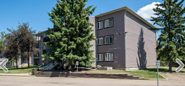 St. Albert apartment for rent - an apartment building on the corner of a street with trees