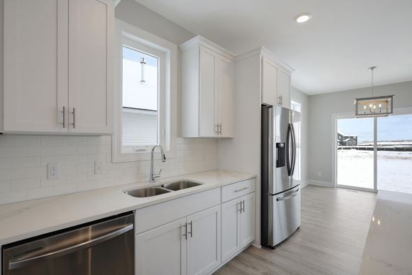 Hastings house for rent - a kitchen with white cabinets and a stainless steel refrigerator