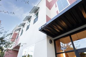 Sacramento apartment for rent - A building with a red and white facade and a black awning.