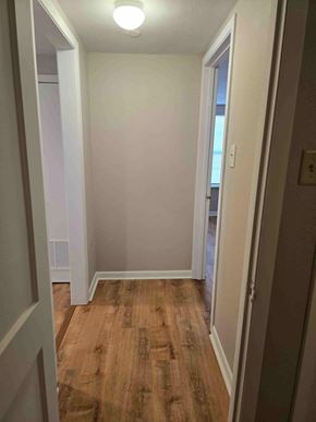 Bay City apartment for rent - A hallway with wood flooring and white walls.
