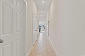 Fort Wayne apartment for rent - A long hallway with white walls and wood floors.