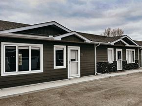 Ste.Anne apartment for rent - A row of houses with grey siding and white trim.