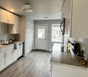 Ste.Anne apartment for rent - A kitchen with white cabinets and a grey floor.