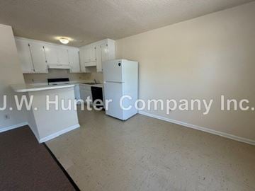 Wilson apartment for rent - A kitchen with white cabinets and a white refrigerator.