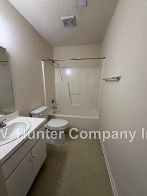Wilson apartment for rent - A bathroom with a toilet, sink, and bathtub.