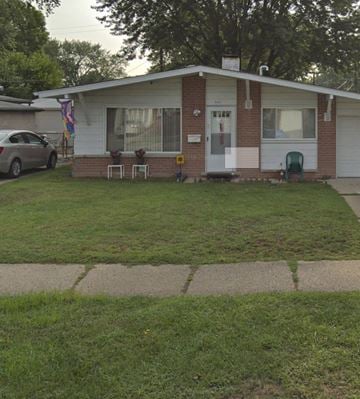 Westland house for rent - A small house with a white door and a green chair in front of it.