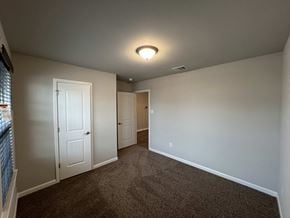 Duson house for rent - a bedroom with a carpeted floor and a door to a closet