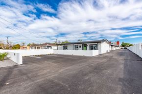 Phoenix apartment for rent - the exterior of a white house with a large parking lot