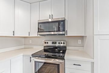 Phoenix apartment for rent - a kitchen with white cabinets and a stove and a microwave