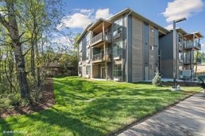 Whitefish apartment for rent - A modern two-story apartment building with a well-maintained lawn in front.