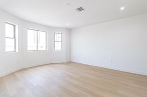 Inglewood apartment for rent - A large empty room with wooden floors and three windows.