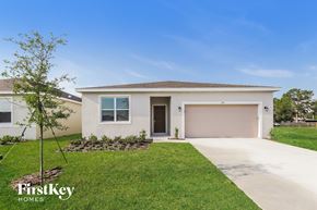 Bartow house for rent - a white house with a garage door and a lawn