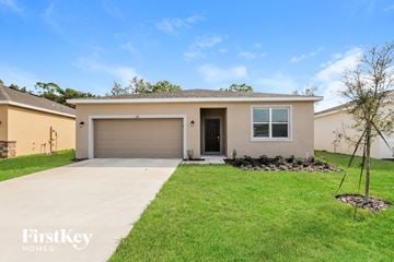 Bartow house for rent - a beige house with a driveway and a garage door