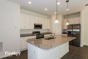 Bartow house for rent - a large kitchen with granite counter tops and white cabinets