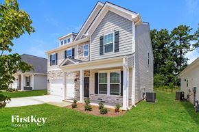 Greenville house for rent - A house with a grey and white exterior and a large front yard.
