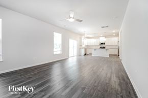 Greenville house for rent - A spacious room with wooden floors and a ceiling fan.