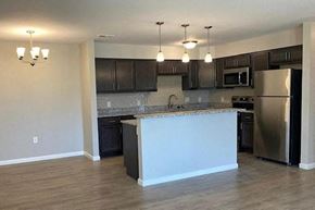 Newburgh apartment for rent - an empty kitchen with an island and stainless steel refrigerator