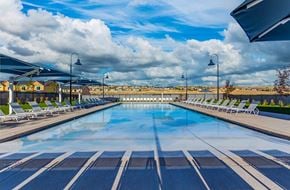 Santaquin house for rent - a large swimming pool with chairs around it and a cloudy sky