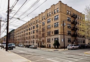 Hoboken apartment for rent - A street view of a residential building with cars parked on the side.