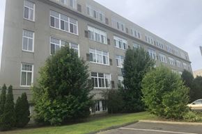 Bridgeport apartment for rent - A grey building with trees in front.