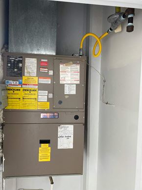 Bridgeport apartment for rent - A wall-mounted furnace with a yellow hose coming out of it.